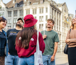 Smiling young friends on city trip to Amsterdam. Group of tourists exploring Amsterdam.