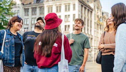 Smiling young friends on city trip to Amsterdam. Group of tourists exploring Amsterdam.