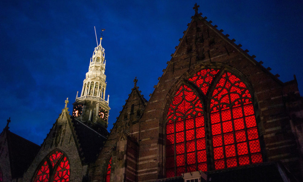A historic Amsterdam church with striking red windows