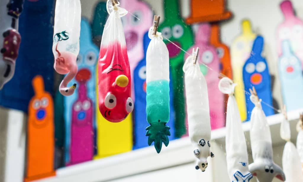 Preservativi di diversi colori appesi a un filo nella Condomerie di Amsterdam