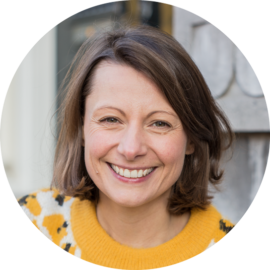 Portrait of a smiling woman with brown hair. Amsterdam city trips expert.
