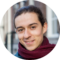 A smiling woman wearing a scarf. She appears to be in Amsterdam.