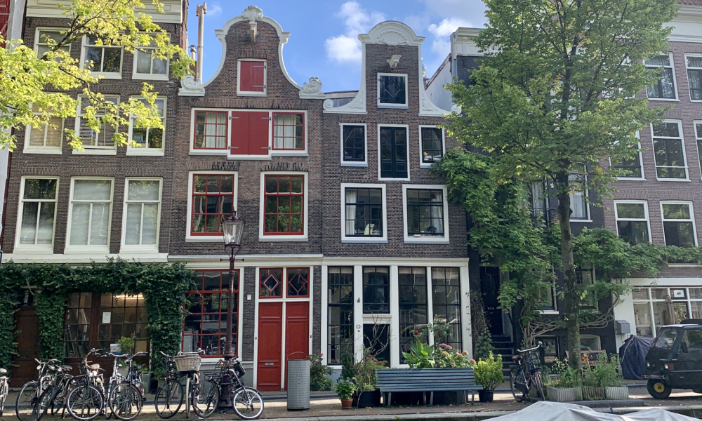 Classic Dutch houses with bicycles parked outside. Beautiful Amsterdam architecture.