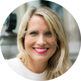 A smiling woman with blonde hair and glasses