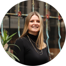 A smiling woman with blonde hair on a city trip. Enjoying Amsterdam.