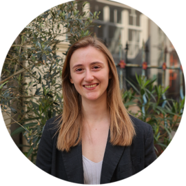 Portrait of a young woman smiling outdoors. Amsterdam city guide.