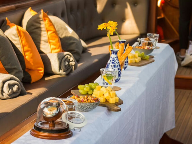 A table with snacks and drinks on a boat. Fresh fruit and glasses are visible.