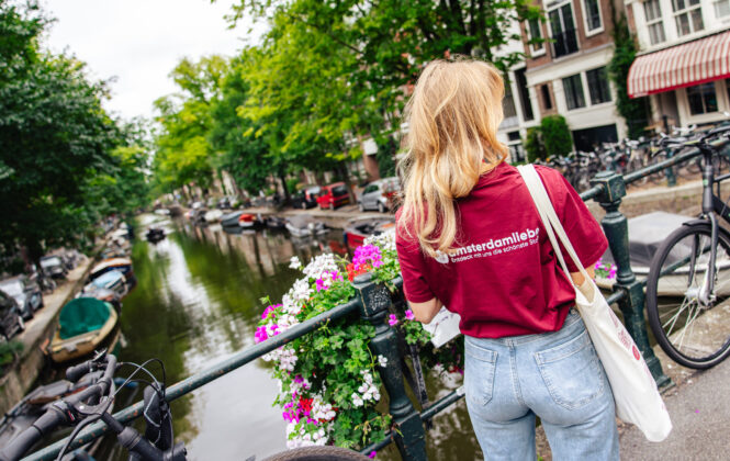 Tour guide Joey standing in front of a canal on a tour through Amsterdam.